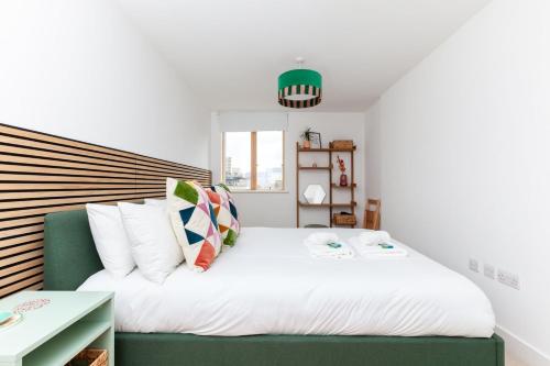 a bedroom with a large white bed with a green couch at GuestReady - Paradise Break in Brighton in Brighton & Hove