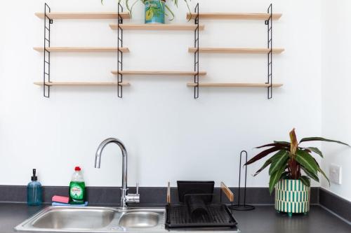 a kitchen counter with a sink and some shelves at GuestReady - Paradise Break in Brighton in Brighton & Hove