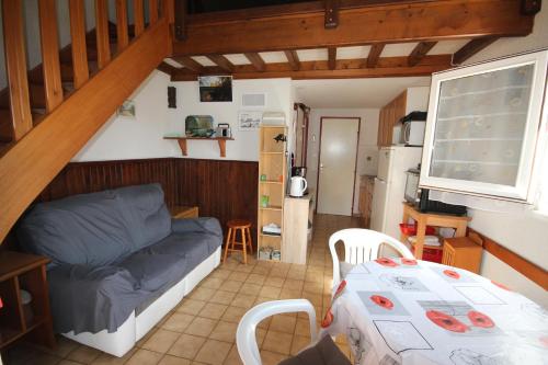 un salon avec un canapé bleu et une table dans l'établissement 300m de la plage, adorable maison 2 chambres 4-6 couchages terrasse parking privatif LRSEN63, à Portiragnes