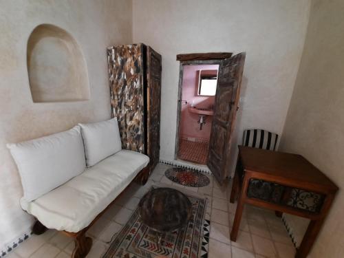 a living room with a white couch and a pink door at Dar Halima in Essaouira