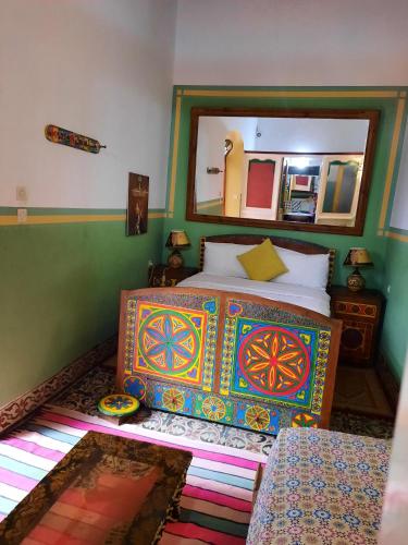 a bedroom with a bed with a large mirror at Dar Halima in Essaouira