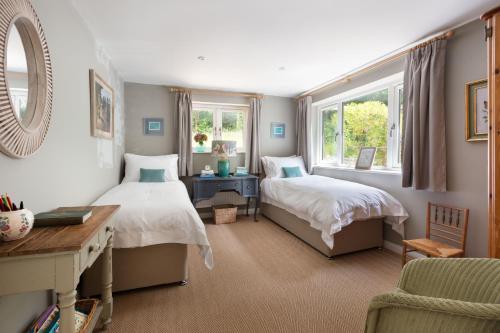 a bedroom with two beds and a mirror at Nest Stay in Pulborough