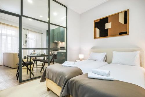 a bedroom with two beds and a dining room at Ponte Nova Studios in Funchal