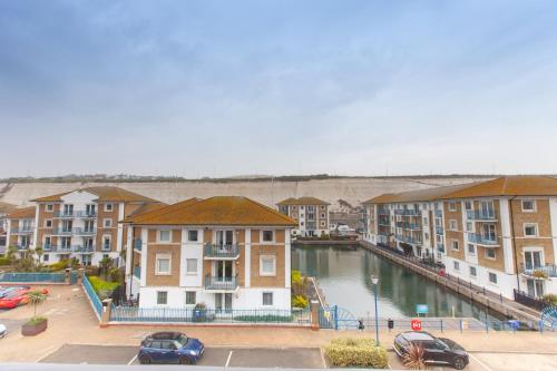 a group of buildings next to a body of water at Stylish Seaside Stay – Brighton Marina Views in Brighton & Hove