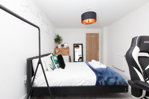 sypialnia z łóżkiem i krzesłem w obiekcie GuestReady - Lush moderno perto do Queen's Park w Brighton and Hove