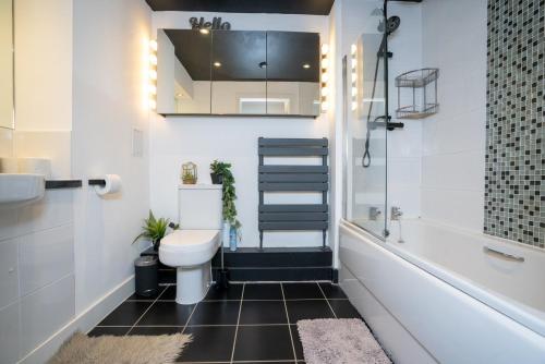 uma casa de banho com um WC, um lavatório e uma banheira em GuestReady - Lush moderno perto do Queen's Park em Brighton & Hove