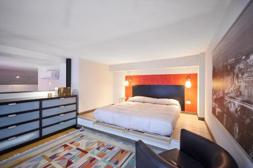 a bedroom with a bed and a dresser in it at Loft Santa Giulia in Turin