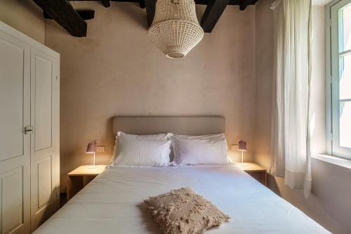 a bedroom with a white bed with two lamps and a pillow at Dandelion Como Suites & Park in Villa Guardia