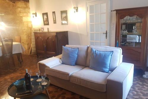 - un salon avec un canapé blanc et des oreillers bleus dans l'établissement In the heart of Sarlat- Charming & Authentic House, à Sarlat-la-Canéda