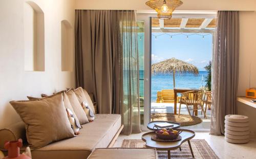 a living room with a couch and a view of the ocean at Aegean Stories pelagos suites in Avlákia