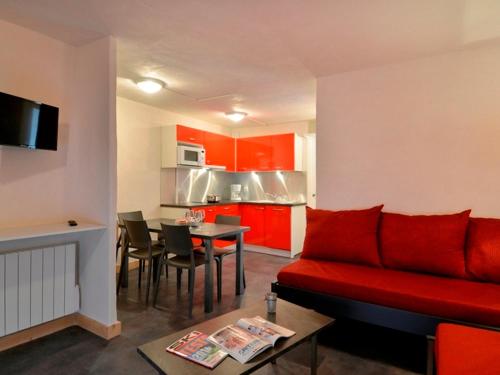 un salon avec un canapé rouge et une cuisine dans l'établissement Appartement rénové au centre, tout confort, animaux admis - FR-1-181-1947, à La Plagne Tarentaise