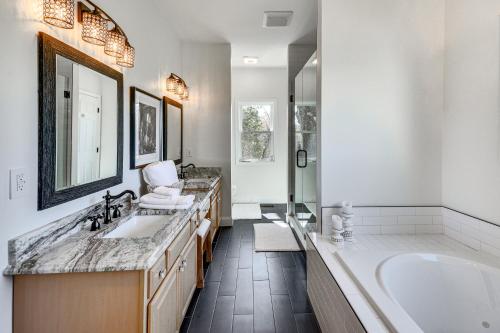 a bathroom with two sinks and a bath tub at Bright and Elegant Home in High Point with Deck! in High Point