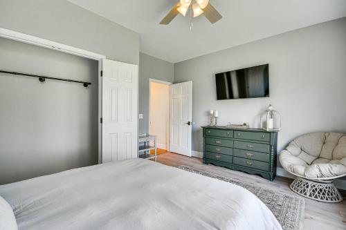 a bedroom with a bed and a chair and a tv at Bright and Elegant Home in High Point with Deck! in High Point