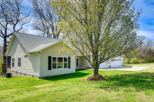 a small house with a tree in the yard at Bright and Elegant Home in High Point with Deck! in High Point