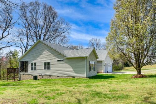 a white house with a tree in the yard at Bright and Elegant Home in High Point with Deck! in High Point