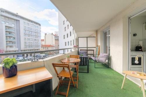 einen Balkon mit einem Tisch und Stühlen sowie einem Fenster in der Unterkunft Fonctionnel et Calme avec parking gratuit in Villeurbanne