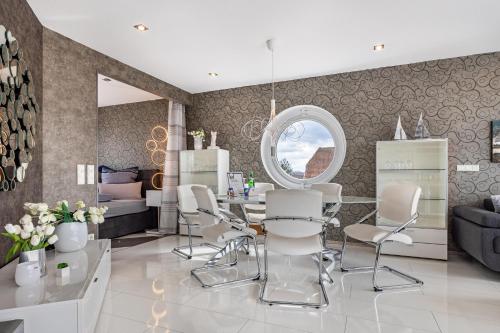 a living room with a table and white chairs at Studio Comfort in Steinhude