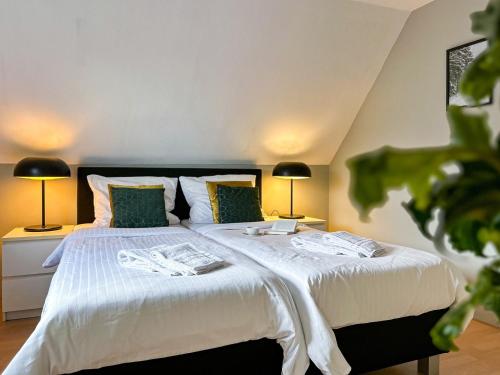 a bedroom with a bed with white sheets and two lamps at Vakantiehuis Bergfreiheit in Winterberg