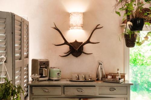 a room with a table with a antler on the wall at Dandelion Como Suites & Park in Villa Guardia
