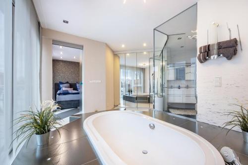 a bath tub in a bathroom with a bedroom at Studio Comfort in Steinhude