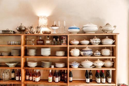 a shelf filled with lots of dishes and pottery at Dandelion Como Suites & Park in Villa Guardia