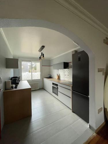 une cuisine avec une arche au milieu dans l'établissement Maison Quartier de Pors Carn, à Penmarcʼh