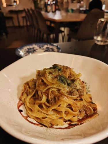 a plate of pasta with meat and vegetables on a table at Dandelion Como Suites & Park in Villa Guardia