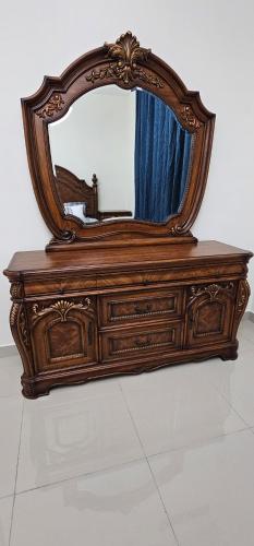 un tocador de madera con un espejo encima en Luxury Private Room in Sharjah, en Sharjah