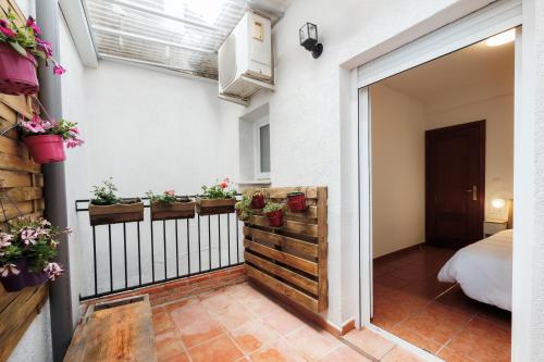 um quarto com uma varanda com vasos de plantas em La Casita de la Gula em Jarandilla de la Vera