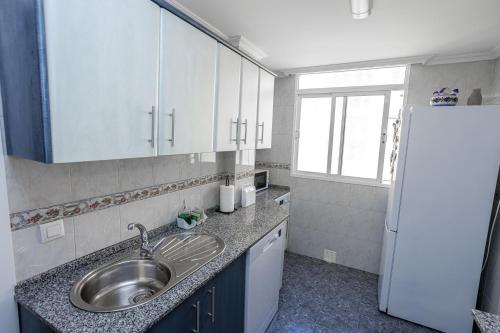 uma cozinha com um lavatório e um frigorífico em Apartamento Playa Santa María del Mar em Cádiz