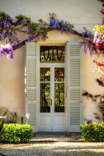 a door to a house with purple flowers at Dandelion Como Suites & Park in Villa Guardia