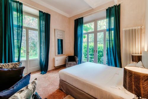 a bedroom with a bed and two windows at Dandelion Como Suites & Park in Villa Guardia