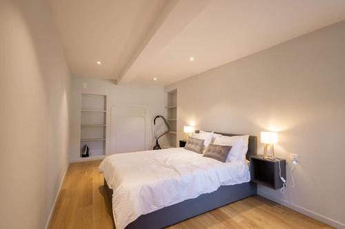 een slaapkamer met een groot bed met 2 lampen bij 3.5 pièces Altstadt « Junkergasse » in Visp