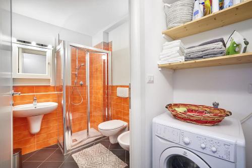 a bathroom with a shower toilet and a washing machine at Loft Santa Giulia in Turin
