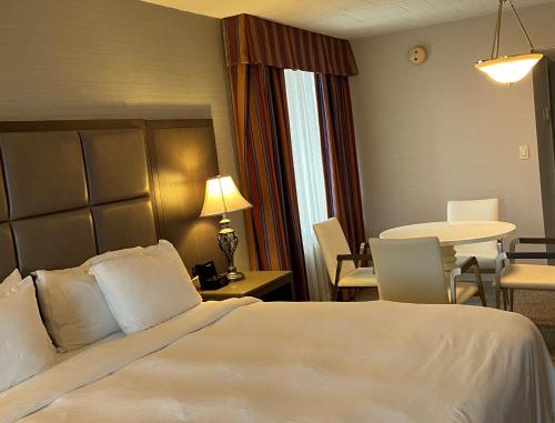 a hotel room with a bed and a table and chairs at Radisson Hotel Hauppauge-Long Island in Hauppauge
