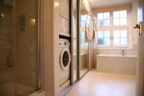 a bathroom with a washing machine and a shower at Garden flat in a quiet Camden spot in London