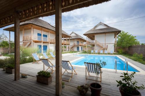 a deck with chairs and a swimming pool at Limanul Resort - Danube Delta in Chilia Veche