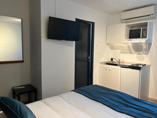 Cette chambre comprend un lit, un four micro-ondes et une cuisine. dans l'établissement Appart'Hotel Festival Sud Suites - Avignon TGV, à Avignon