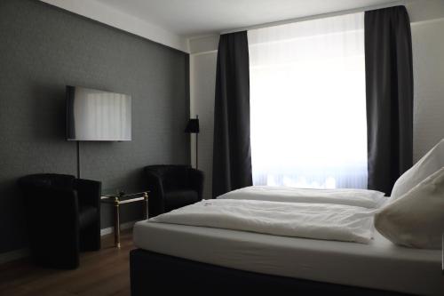 a bed in a room with a large window at Hotel St. Georg in Ediger-Eller