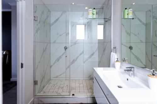 a white bathroom with a shower and a sink at City Nest:Heart of Linksfield II in Johannesburg