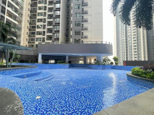 een groot zwembad met blauwe tegels voor gebouwen bij R&F Princess Cove 3-1 DS Homestay 民宿 in Johor Bahru