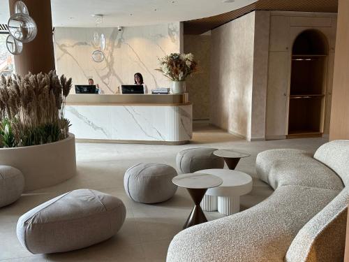 a lobby with a reception desk with two people on their laptops at Hotel Marina Port in Balatonkenese