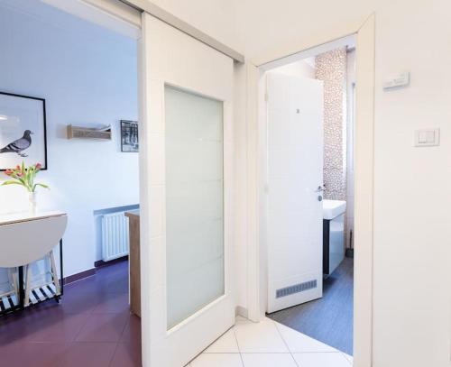 a bathroom with white walls and a sink and a mirror at cozinesT eco apartment in Zagreb