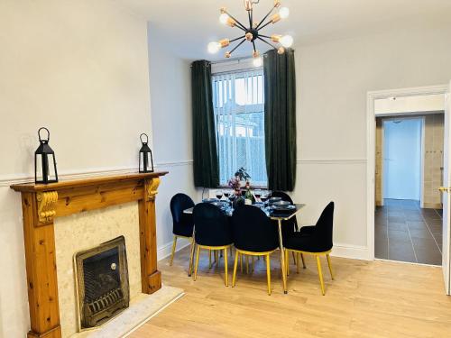 a dining room with a table and a fireplace at LakeDistrict Sweetness by Sleepy in Millom