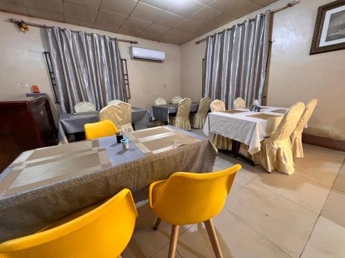 a waiting room with tables and chairs in a room at ROYAL HOTEL in Juba