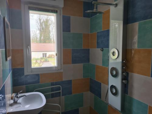 a bathroom with a sink and a window at Chez Jaja et Phiphi in Bourg-et-Comin