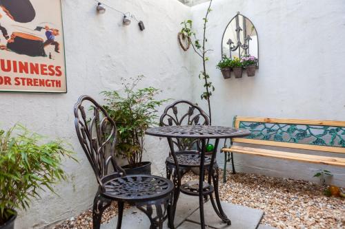 a table and chairs and a bench in a courtyard at GuestReady - Interiores pitorescos em Brighton in Brighton & Hove