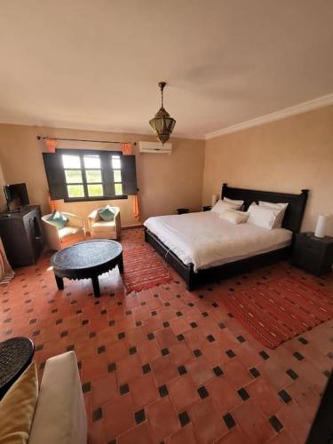a bedroom with a bed and a table and a couch at Villa Tifira in Marrakech