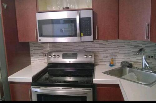 a kitchen with a stove and a microwave at Condado 1 bedroom Apt w/ View in San Juan