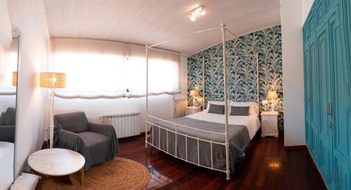 a bedroom with a canopy bed and a chair at Vila Sen Vento - Aguiño in Ribeira